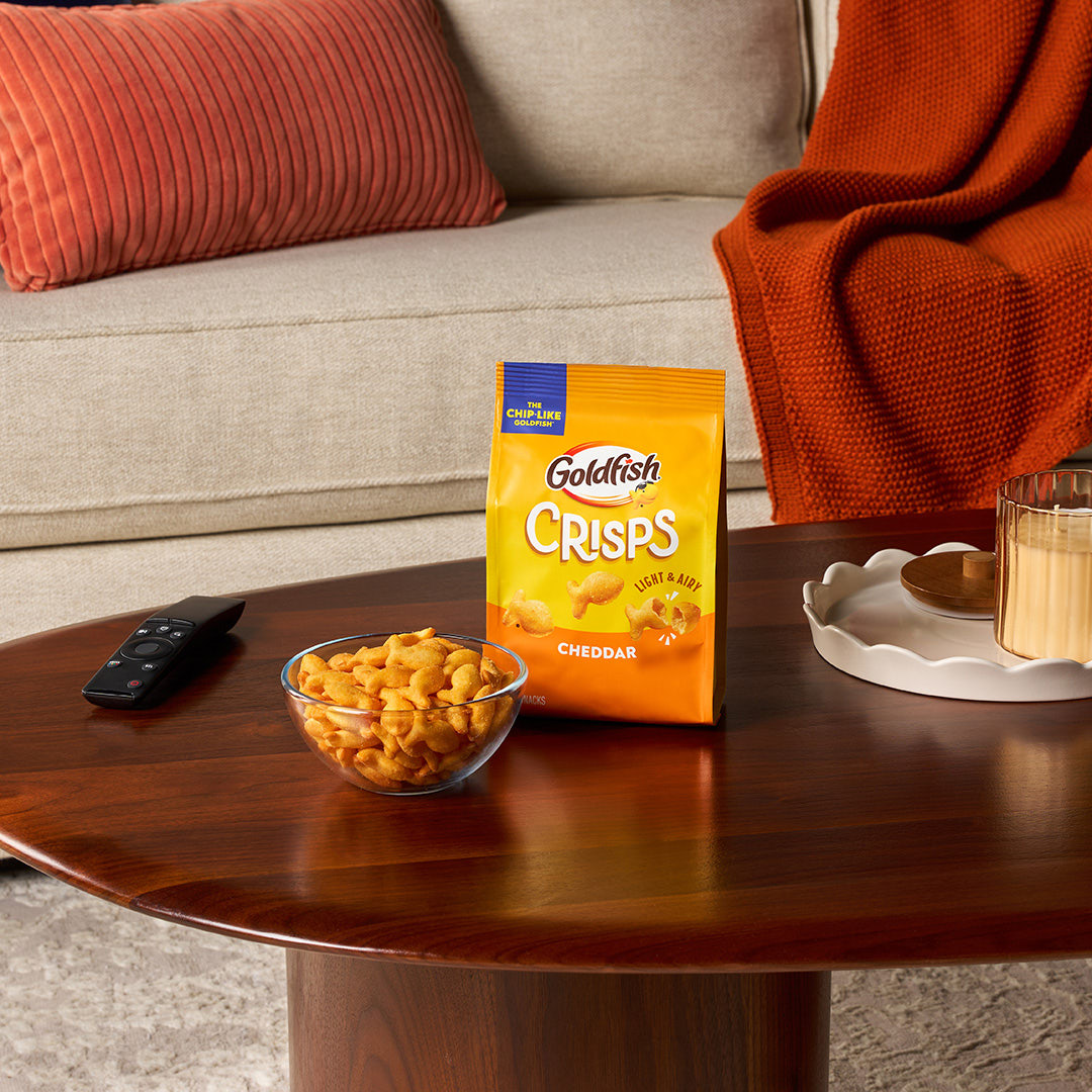 Goldfish Crisps crackers with a bowl of crackers on a coffee table in a living room setting.